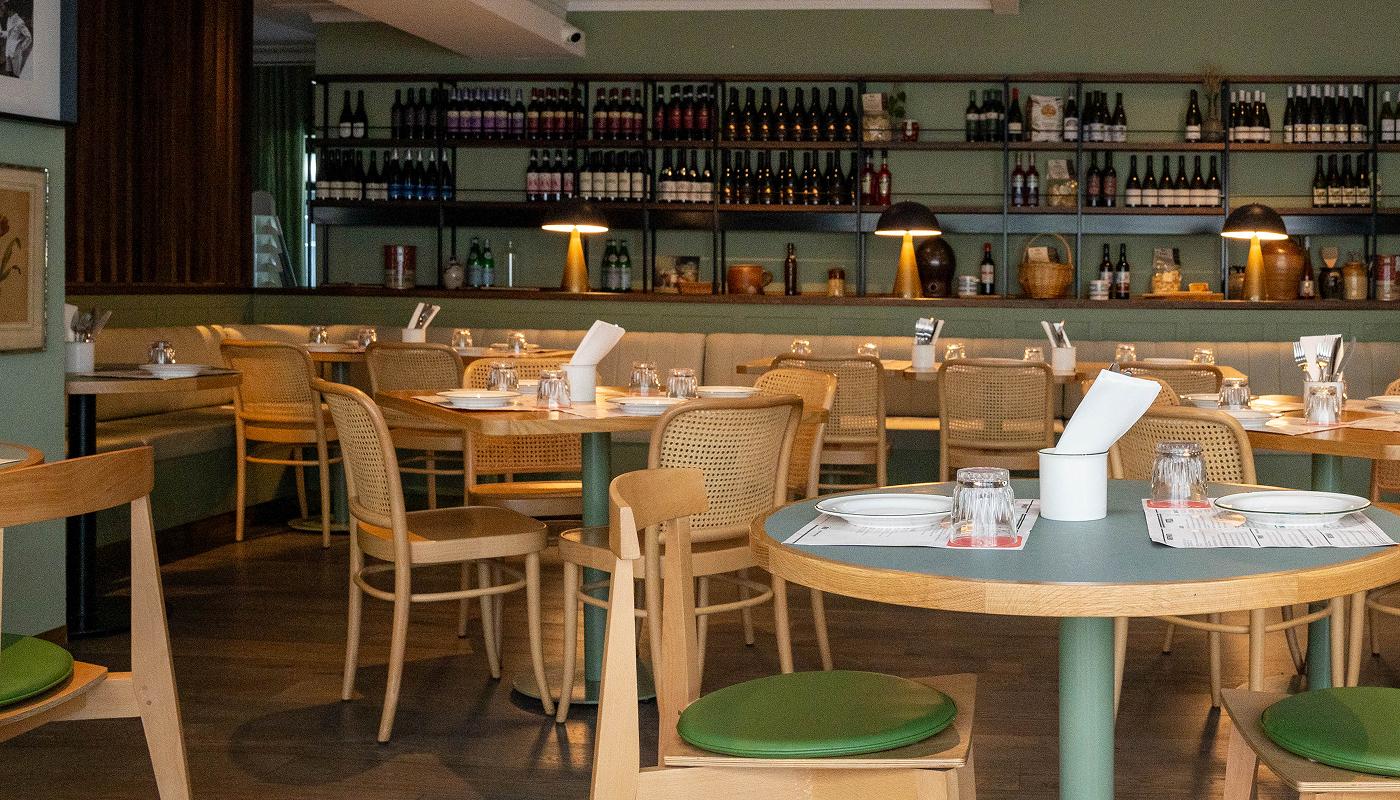 The trattoria dining room lined with wine shelves