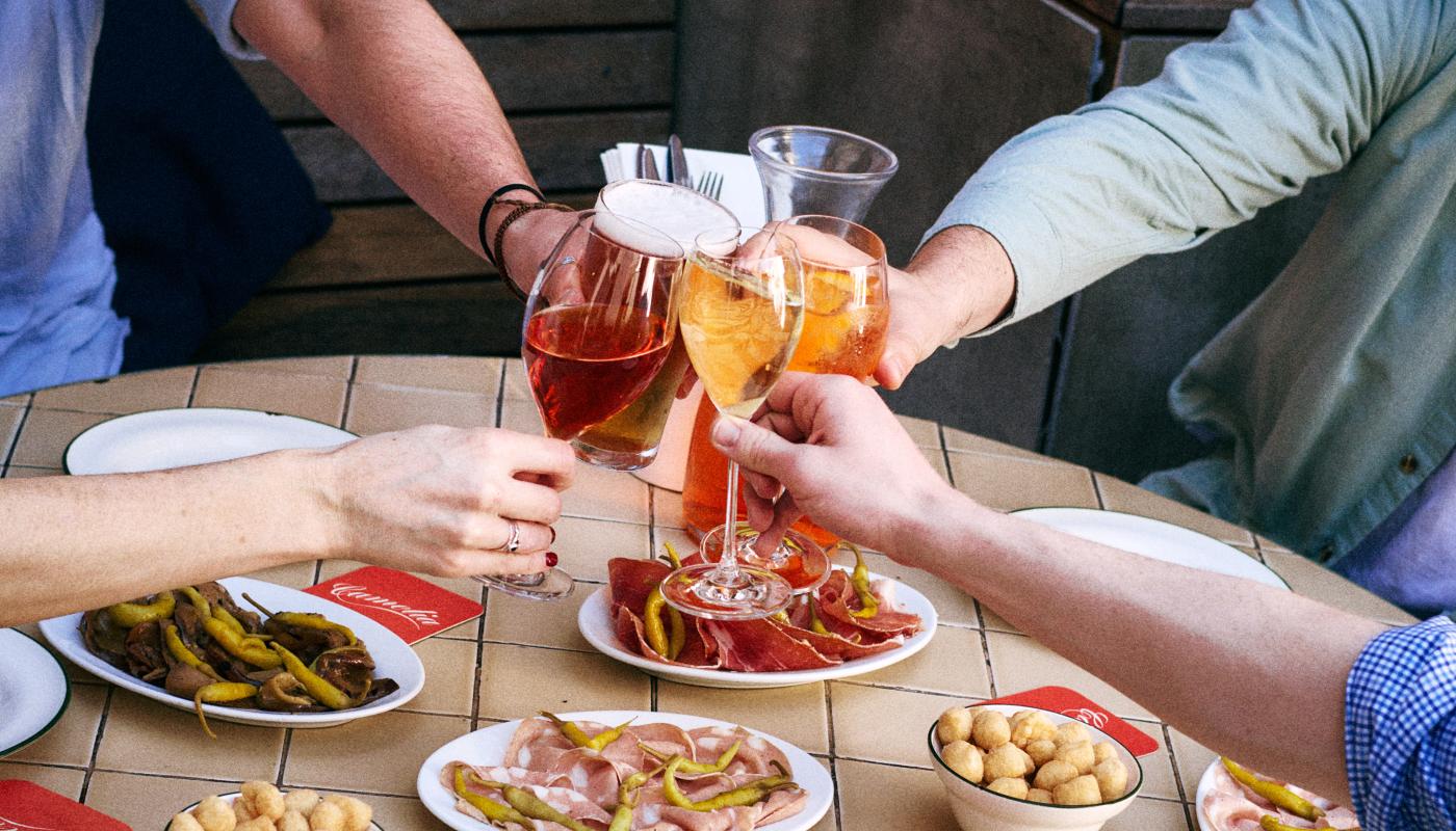 Glasses raised over antipasti plates