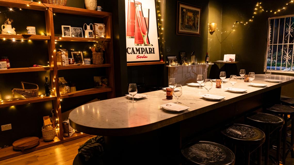 The private dining room — marble table, fairy lights and Campari posters