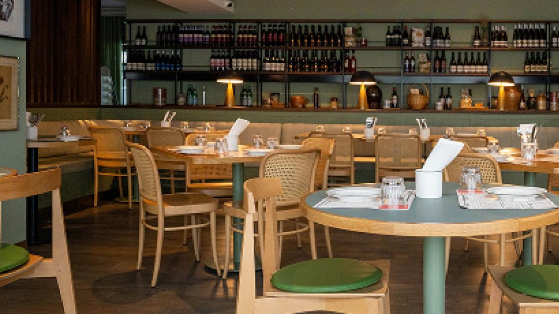 The dining room — sage walls lined with wine shelves