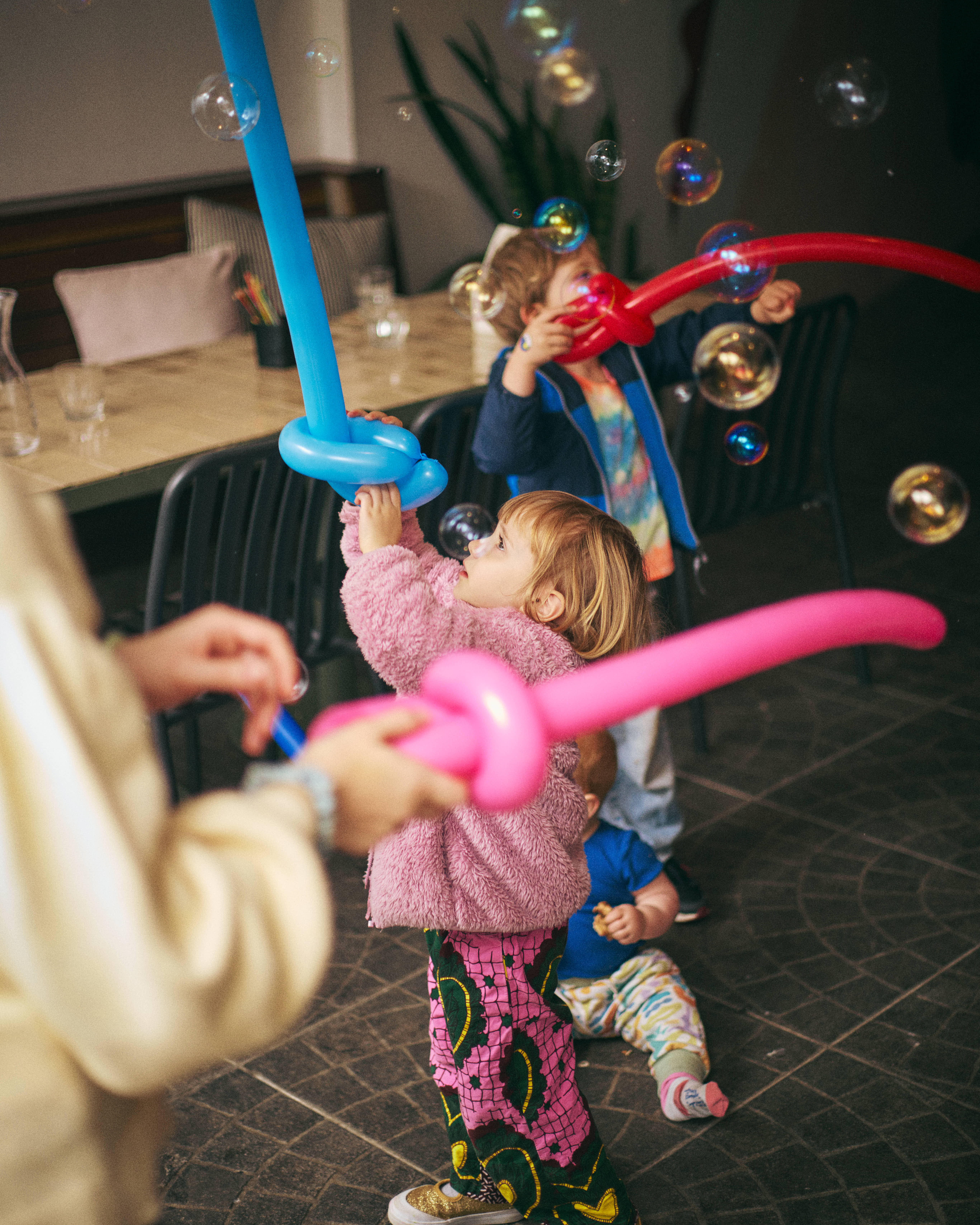 Kids chasing bubbles with balloon swords