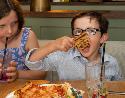 Kid tucking into pizza
