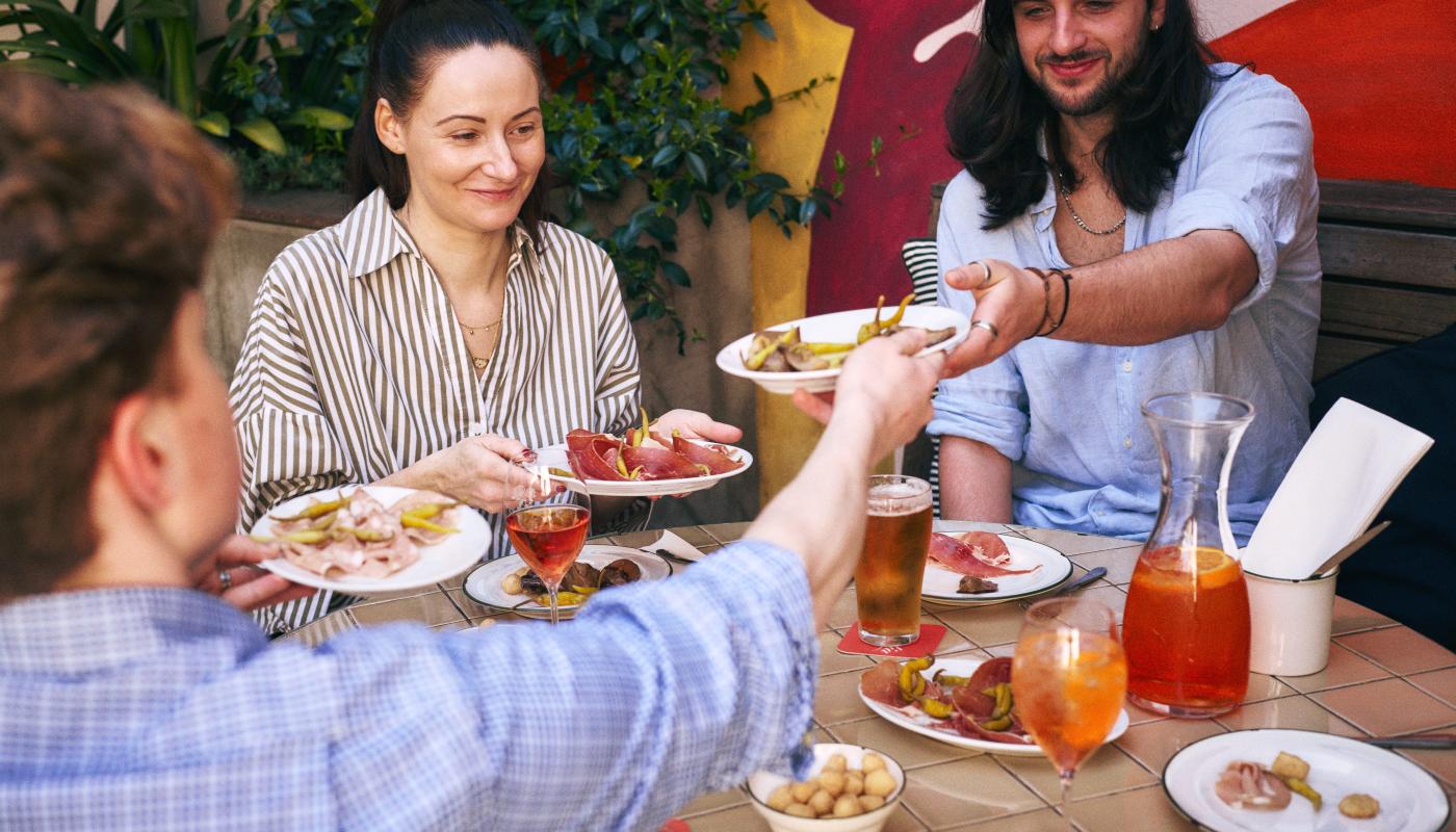 Friends passing antipasti plates in the garden