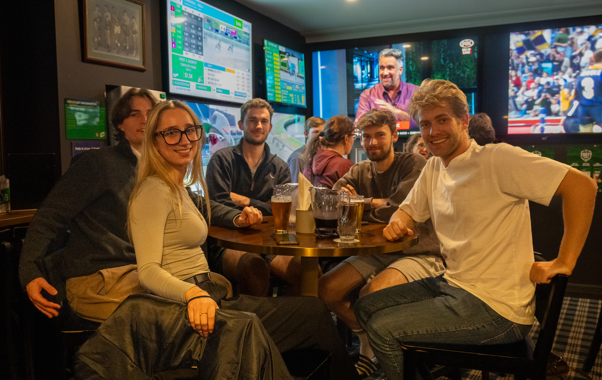 Friends with jugs of beer in the sports bar