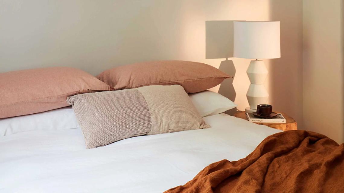 Studio apartment bedroom in warm linen tones